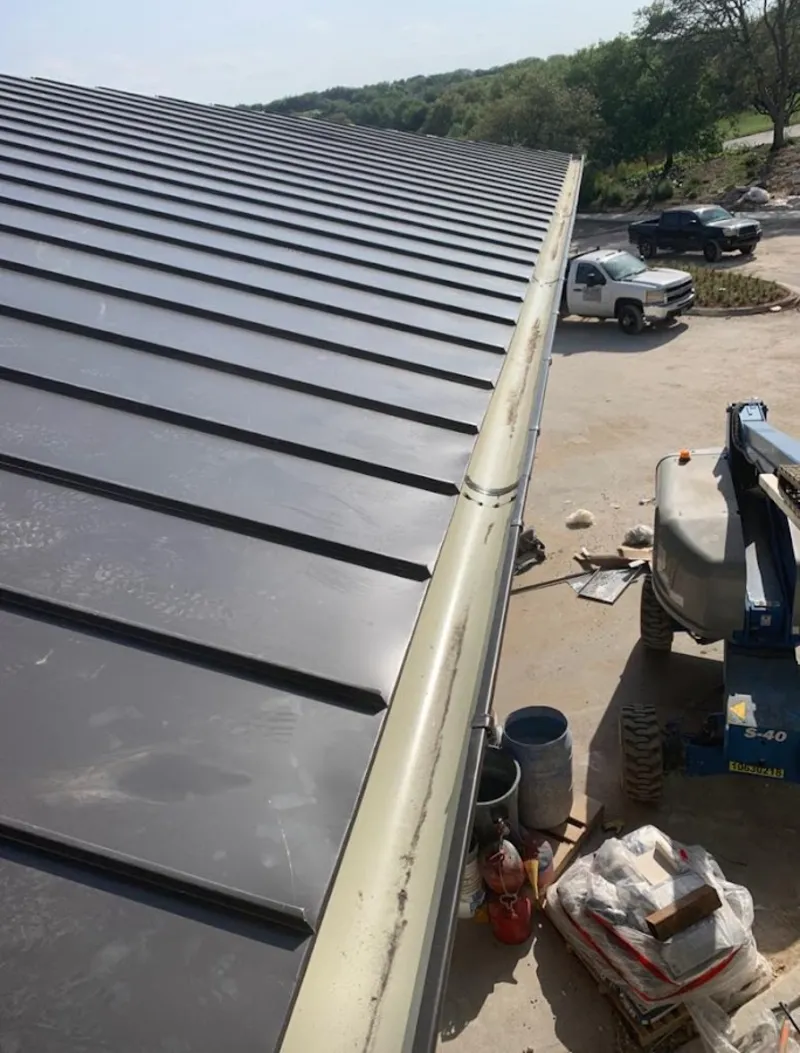 Standing seam panel and gutter detail on a metal roofing jobsite in Fulton